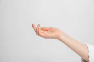 A woman's hand raised, palm up, in the frame is part of the robe.