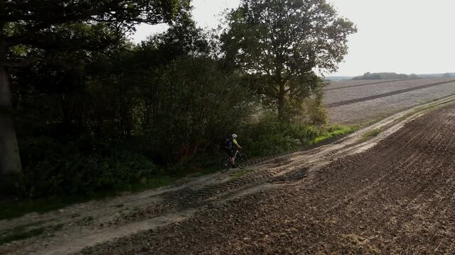 Drone Tracking Side Profile Mountain Bike On Field Track 