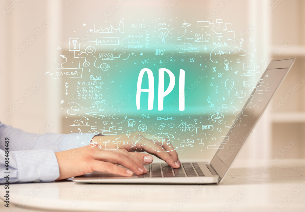 Aufkleber hand working on new modern computer with API abbreviation, modern technology concept
