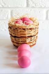 Fototapeta na wymiar Easter composition with wicker basket and pink colored eggs