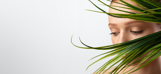 Naklejka premium Portrait Of Ginger-Haired Girl Posing With Green Plant, White Background
