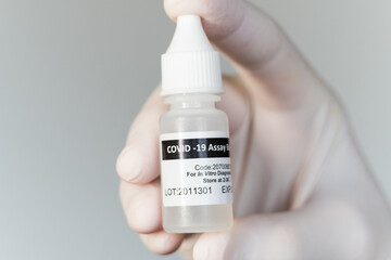 Covid-19 assay buffer sample to detect coronavirus via Antigen test. The bottle with the liquid is...
