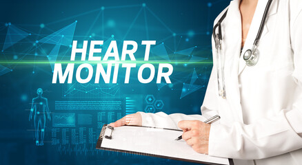 doctor writes notes on the clipboard with HEART MONITOR inscription, medical diagnosis concept