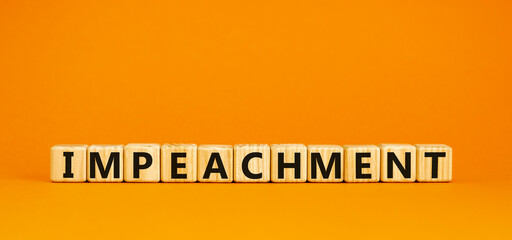 Impeachment symbol. Wooden cubes with the word 'impeachment'. Beautiful orange background, copy space. Business, impeachment concept.