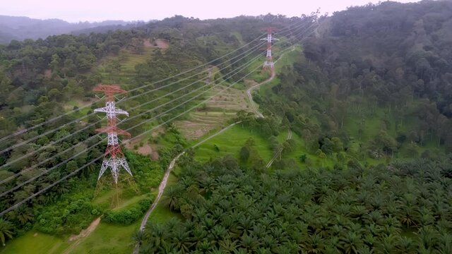 Aerial view fly over electric tower at hill during misty day