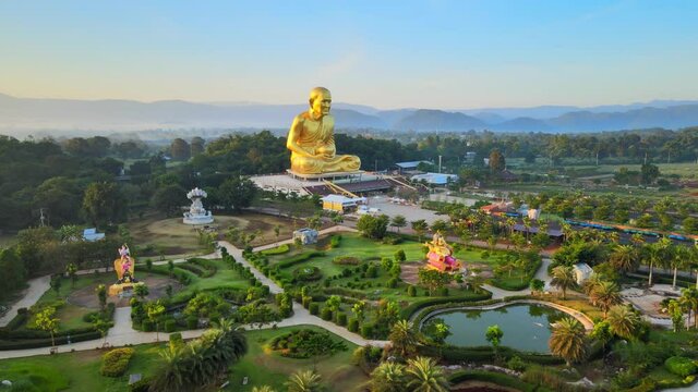 4k Stunning statue of Ganesha and biggest Luang Pu Thuat in the world. pan around an elephant-headed Hindu god of beginnings Ganesh in Khao Yai mountains, Thailand. Sun glares at dawn. right to left