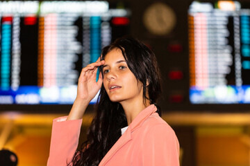 Beautiful young traveler woman waiting at the airport terminal for her flight. Concept about lifestyle, people and travel. 