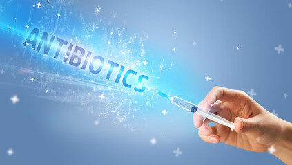 Syringe, medical injection in hand with ANTIBIOTICS inscription, medical antidote concept
