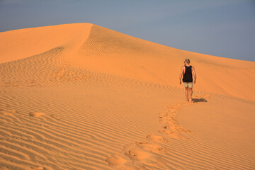 Fototapeta na wymiar young man in red sand dunes in Mui Ne, Vietnam
