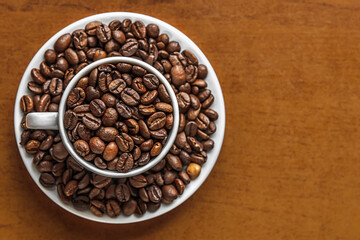 coffee beans in white porcelain cup and saucercoffee beans in white porcelain cup and saucer top view