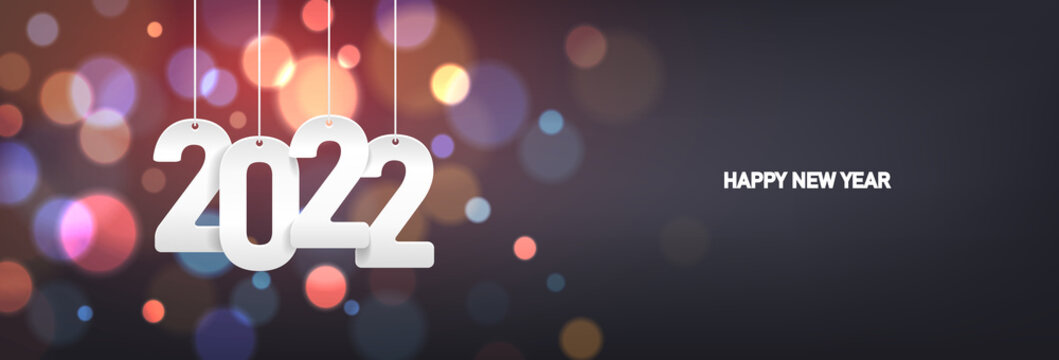 Happy new year 2022. Hanging white paper number on a horizontal colorful blurry background.
