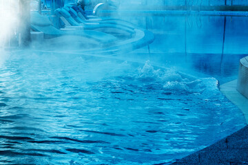 Hot spring, pool with hot mineral water. Steam over the outdoor pool in winter.