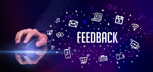 hand holding wireless peripheral with FEEDBACK inscription, social media concept