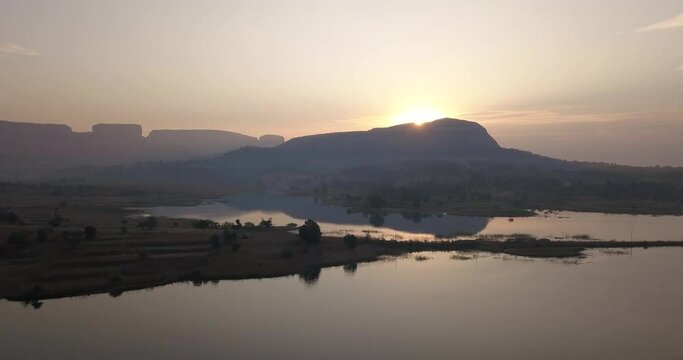 Sun rising behind the rock mountains of Trimbakeshwar, Maharashtra, India -aerial