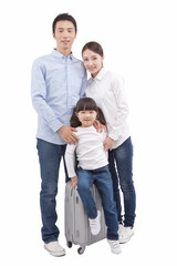 Fototapeta na wymiar Portrait of daughter sitting on valise,parents standing behind 