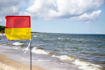 the yellow-red flag for the area on the Baltic Sea on the island of Usedom monitored by lifeguards..