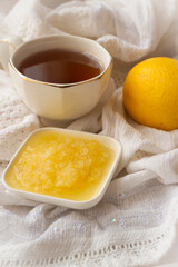 Healthy bowl of pure honey with honey dipper and lemon fruit and puree on vintage white background.