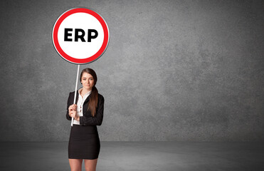 Young business person holdig traffic sign with ERP abbreviation, technology solution concept