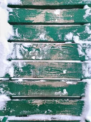 Foto auf Leinwand Schnee auf einem Holzbohlenboden einer offenen Terrasse aus nächster Nähe. Grüner hölzerner schneebedeckter Hintergrund. © Albert Ziganshin