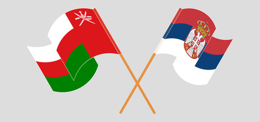 Crossed and waving flags of Oman and Serbia