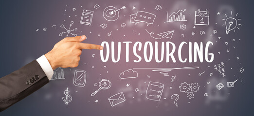 Close-Up of cropped hand pointing at OUTSOURCING inscription, modern business solution concept