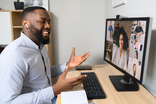 View Over African Guy Shoulder Using Computer. PC Screen View Diverse People Chatting Via Video Call On The Distant. App For Remote Communication With A Many People In Same Time, Virtual Meeting