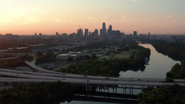A Golden Sunrise backlighting Austin's downtown Skyline with a busy mopac expressway in the foreground