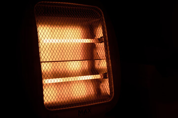 Glowing heating elements of the heater in the dark in the bathroom