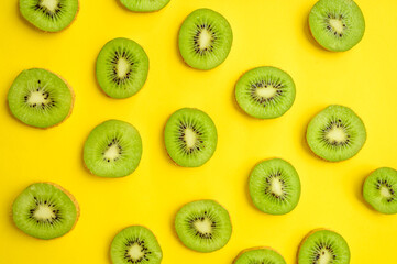 Fresh kiwi slices isolated on yellow background