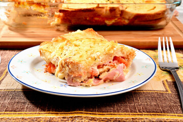 Sanduíche de presunto, tomate e queijo grelhado servido num prato