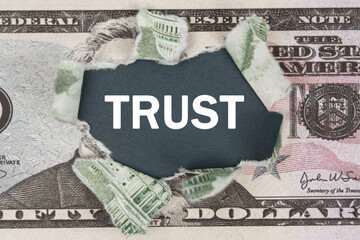 The dollar is torn in the center. In the center it is written - TRUST