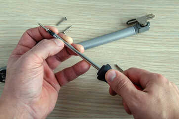 The master assembles and installs a gas-oil lift rack on furniture.