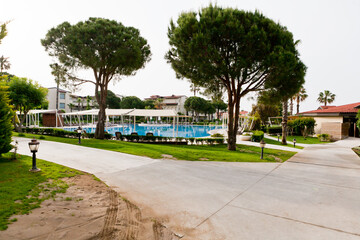 Naklejka premium Hotel pool surrounded by trees by the sea
