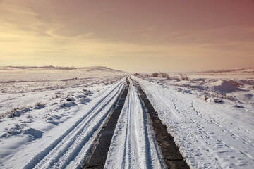 snowy road with landscape at sunset