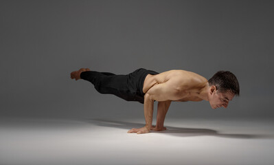 Male yoga keeps horizontal balanc on hands