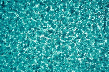 Light blue green tinted winter background or wallpaper. Ice crystals on the window pane close-up. The backdrop looks like a pile of broken glass. Top view from above. Macro