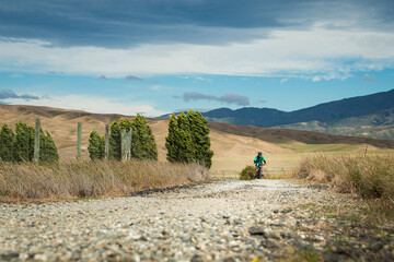 A man cycling the Otago Central Rail Trail in the strong wind