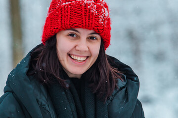 portrait of young pretty woman in winter outfit in the middle of snowed forest.