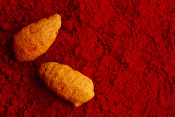 Turmeric and kumkum powder on white background.