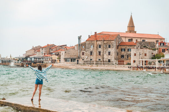 woman walking by umag city quay at stormy weather. copy space