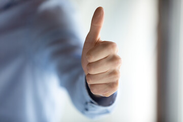 Close up hand view, businessman entrepreneur showing thumbs up gesture, excited by business achievement, client recommending good service, employee intern satisfied by job, career, great news