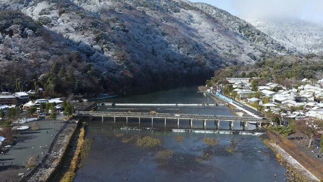 Aerial Arashiyama after snow in Kyoto, Japan. Togetsukyo Establishing shot