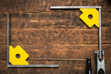 Welding machine terminals and magnetic corners with metal frame on the workbench background with...