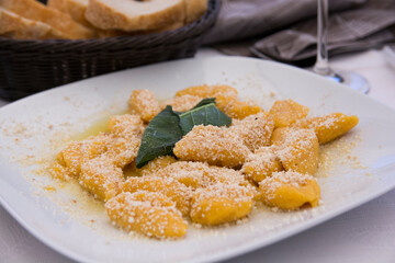 A traditional Italian dish: Pumpkin Gnocchi with Parmesan cheese and a decorative sage leaf
