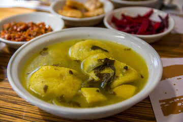 Traditional hot yellow Kubbe soup, a famous middle eastern dumplings soup dish, served in a bowl. Jerusalem, Israel. 