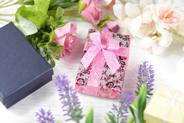 Romantic composition for Valentine day, wedding, birthday. Gift boxes, flowers, box wrapped in pink paper and rose lavender sakura  flowers on white table top view. 