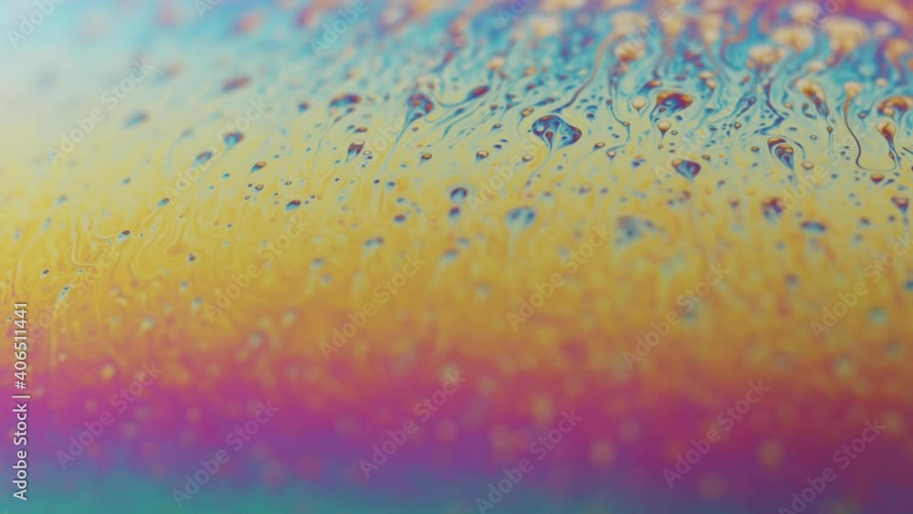 Poster liquid showing a colors of the rainbow and moving in slow motion. multiple small drops rising to the