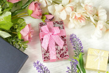Romantic composition for Valentine day, wedding, birthday. Gift boxes, flowers, box wrapped in pink paper and rose lavender sakura  flowers on white table top view. 