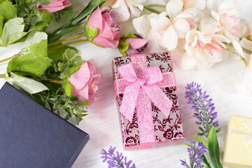 Romantic composition for Valentine day, wedding, birthday. Gift boxes, flowers, box wrapped in pink paper and rose lavender sakura  flowers on white table top view. 
