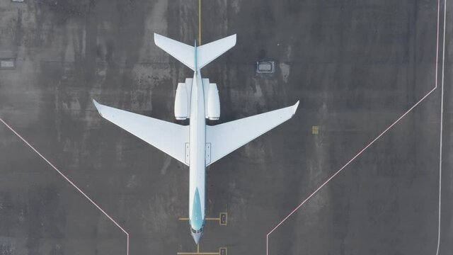 Gulfstream G550 standing inactive on grey tarmac of airfield, aerial